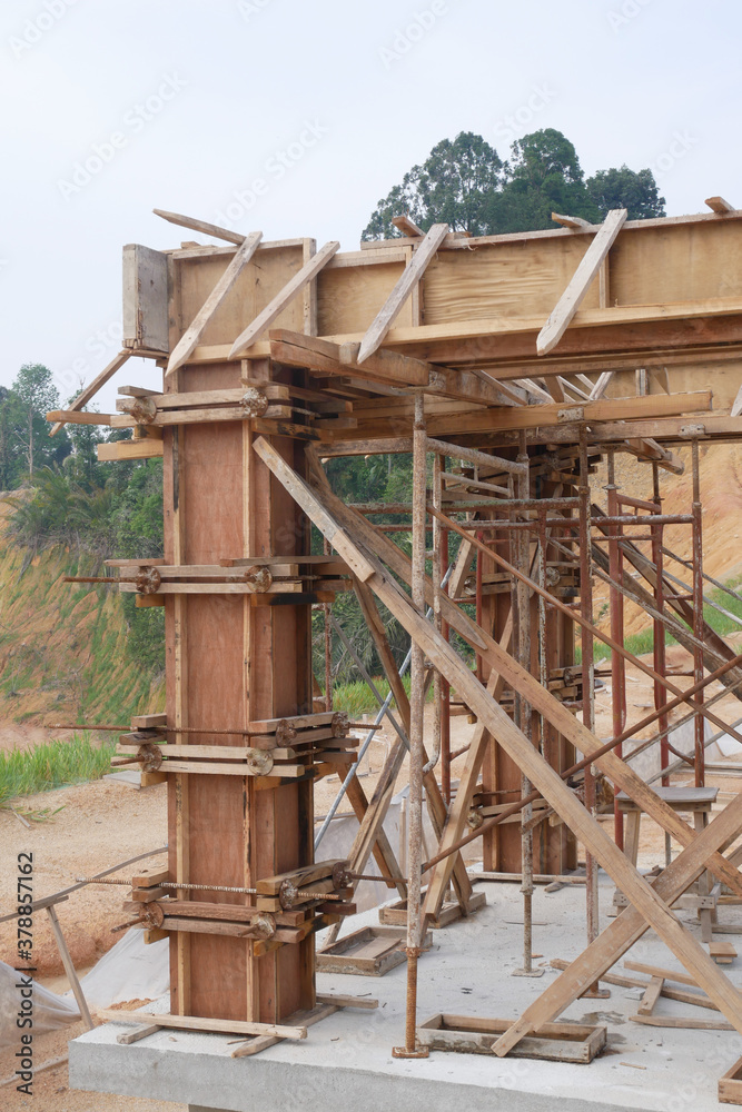 KUALA LUMPUR, MALAYSIA -SEPTEMBER 19, 2020: Column timber form work and reinforcement bar at the construction site. Installed by construction workers. The structure supported by temporary wood support KUALA LUMPUR, MALAYSIA -SEPTEMBER 19, 2020: Column timber form work and reinforcement bar at the construction site. Installed by construction workers. The structure supported by temporary wood support