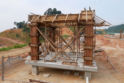 KUALA LUMPUR, MALAYSIA -SEPTEMBER 19, 2020: Column timber form work and reinforcement bar at the construction site. Installed by construction workers. The structure supported by temporary wood support