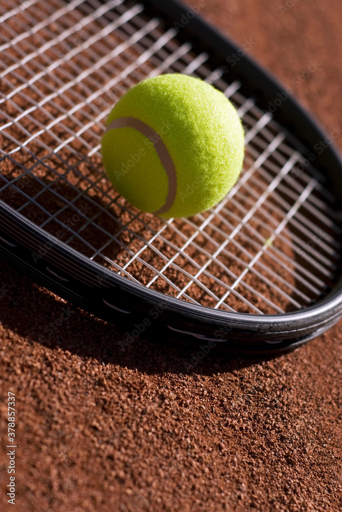 Close-up of a tennis ball on a racket in a court 