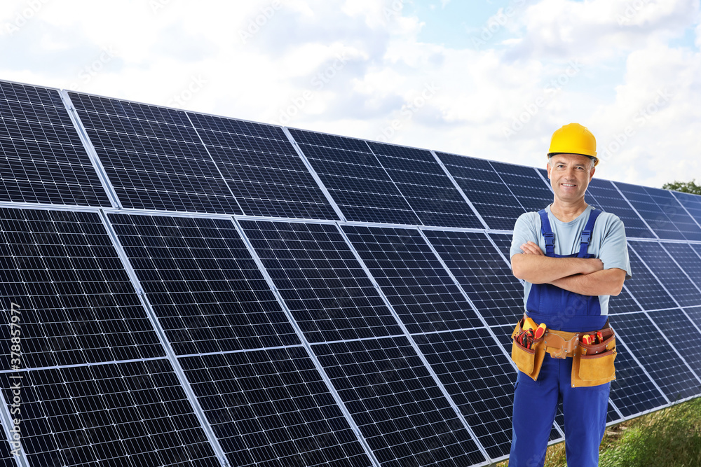 Engineer near solar panels outdoors. Alternative energy source Engineer near solar panels outdoors. Alternative energy source