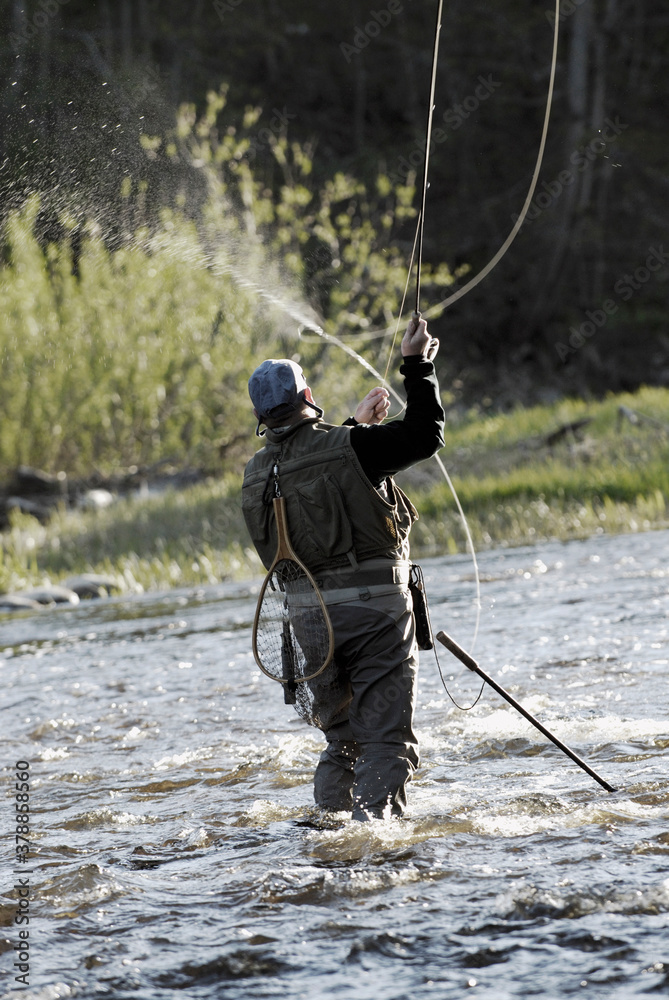 Rear view of a man fishing in the river Rear view of a man fishing in the river