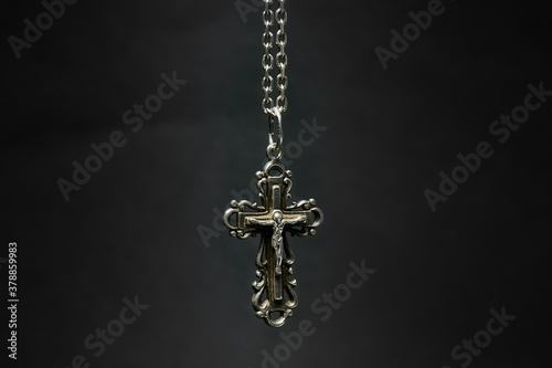 Cross with chain on a dark background.
