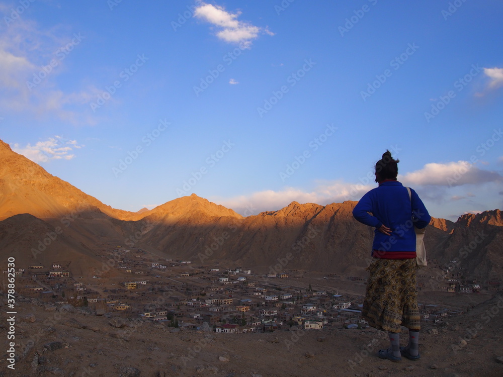 A woman looking down on the historic city streets, Leh, Ladakh, Jammu and Kashmir, India