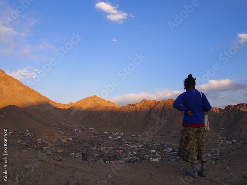 A woman looking down on the historic city streets, Leh, Ladakh, Jammu and Kashmir, India