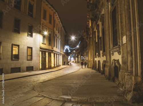 Fototapeta Naklejka Na Ścianę i Meble -  Deserted street with Xmas lights. Christmas city decorations. Festive illumination in Milan center.Italy
