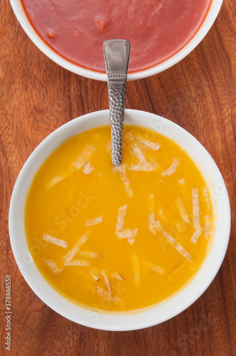 High angle view of bowls of tomato soup and pumpkin soup