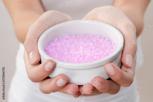 Mid section view of a woman holding a bowl of bath salt
