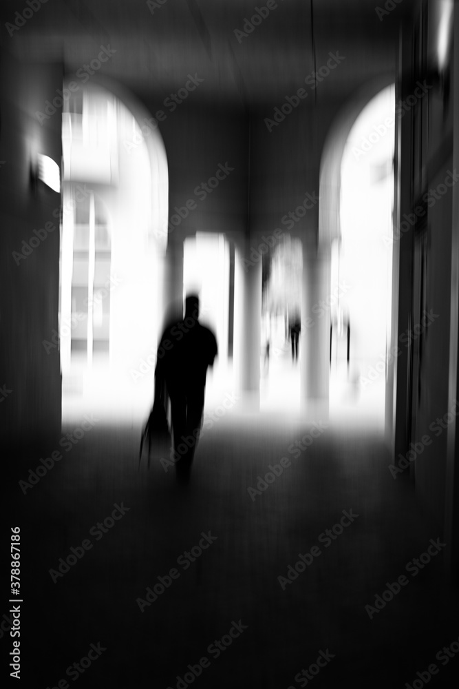 Motion blur image in black and white of man walking in urban ...