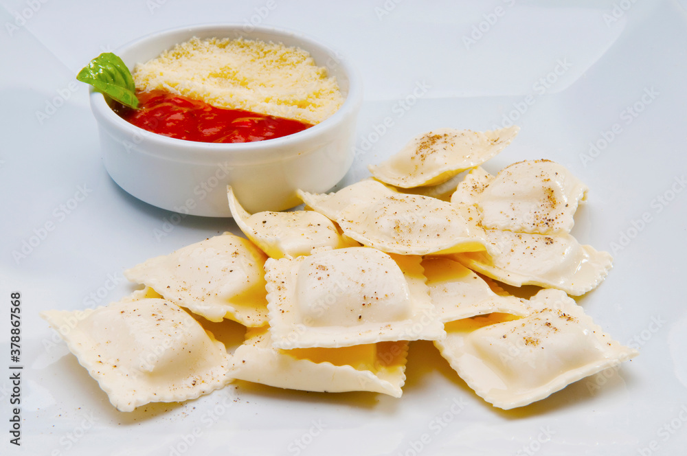 High angle view of ravioli served with tomato sauce and grated cheese High angle view of ravioli served with tomato sauce and grated cheese