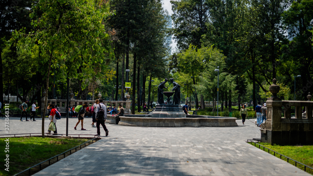 Fountain of Two Women Pouring Down Water Into a Bird Waterer in the Middle of a Park Fountain of Two Women Pouring Down Water Into a Bird Waterer in the Middle of a Park