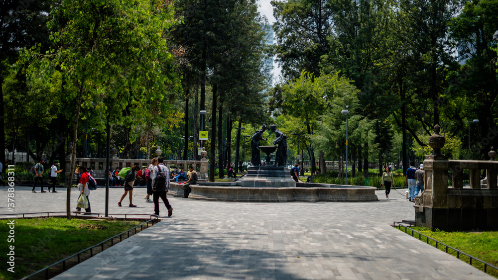 Fountain of Two Women Pouring Down Water Into a Bird Waterer in the Middle of a Park