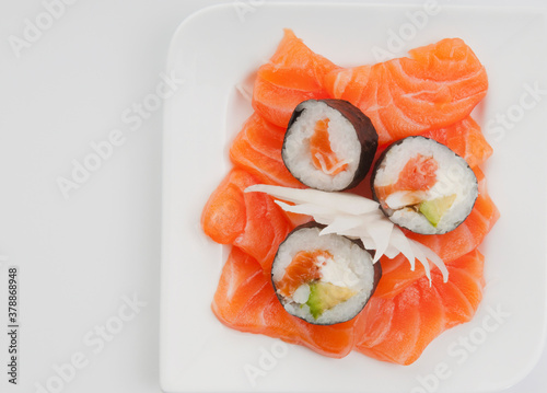 High angle view of sushi rolls on salmon slices