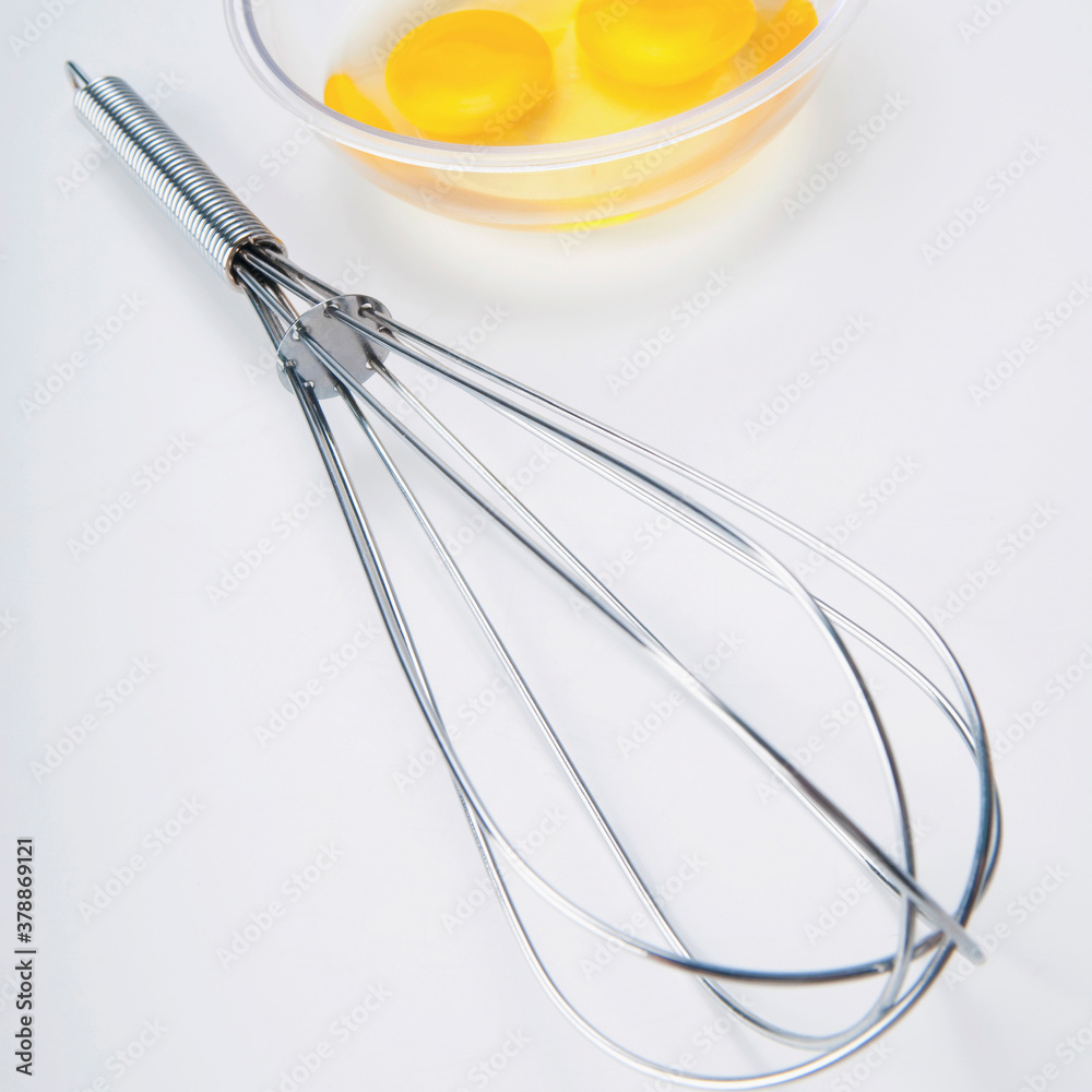 Close-up of a wire whisk and egg yolk in a bowl Close-up of a wire whisk and egg yolk in a bowl