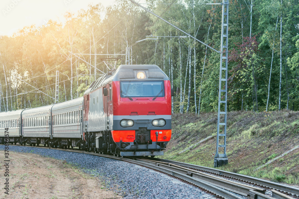 Fototapeta premium Passenger train moves by the forest.