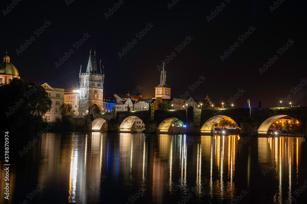 
panorama of charles bridge .monument from 14th century and shining street lamp on it. and on the surface of the Vltava River there are reflections from the lights. at night in the center of Prague