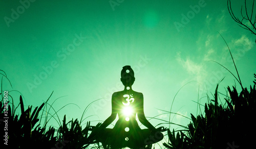 yoga position silhouette in contrasting sun, Heart chakra photo