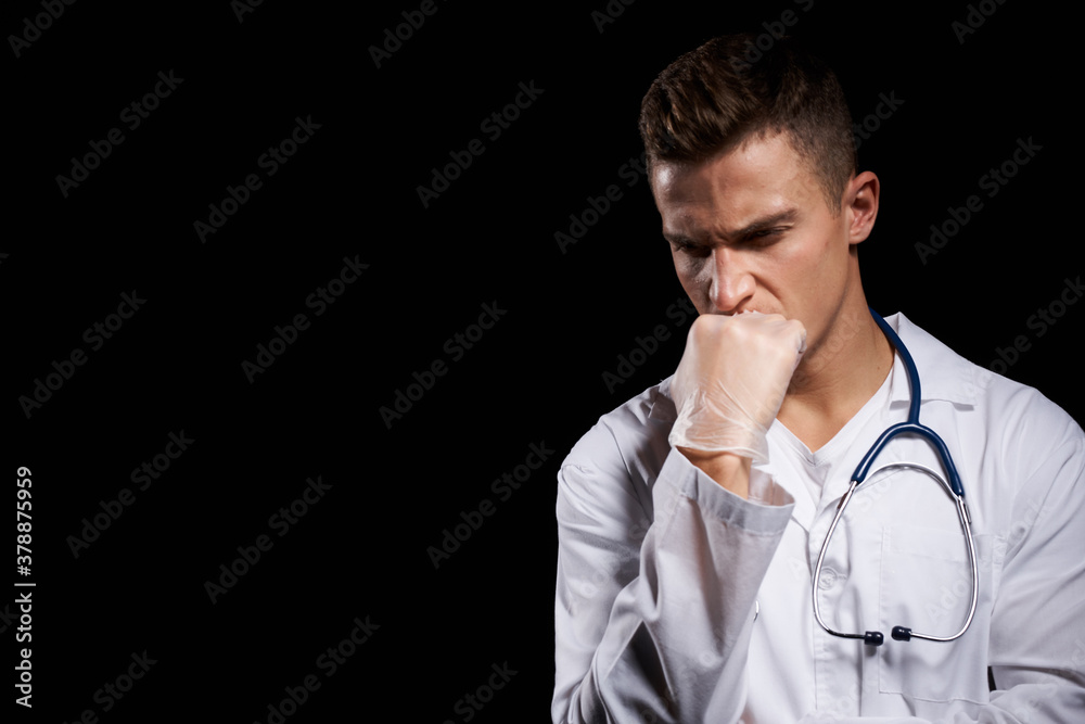 professional doctor in a medical gown with a stethoscope around his neck against a dark background cropped view professional doctor in a medical gown with a stethoscope around his neck against a dark background cropped view