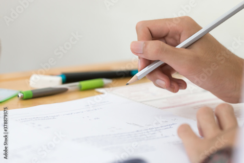 Woman Asian Hands Student testing in exam on exercise taking at high school or university in test room and Writing document exams classroom, back to school and evaluation measurement in education