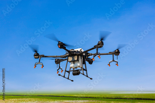 Fototapeta Naklejka Na Ścianę i Meble -  Flying agriculture drone on blue sky with copy space