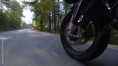 Motorcycle ridind on a road in nature. Close up wheel on a bumpy asphalt road. Speed up video photo