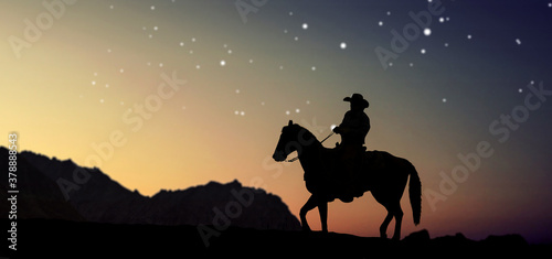 The silhouette of a cowboy on horse with evening night sunset landscape.