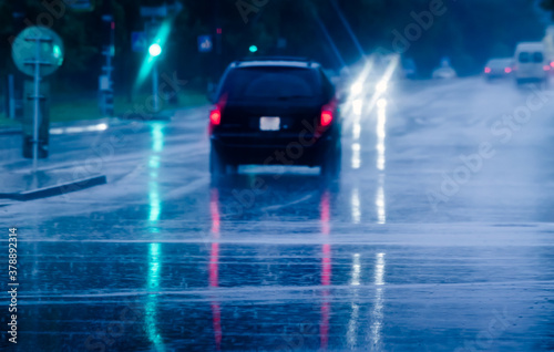 car driving in the city street during a downpour. car traffic at rainy evening. motion blur