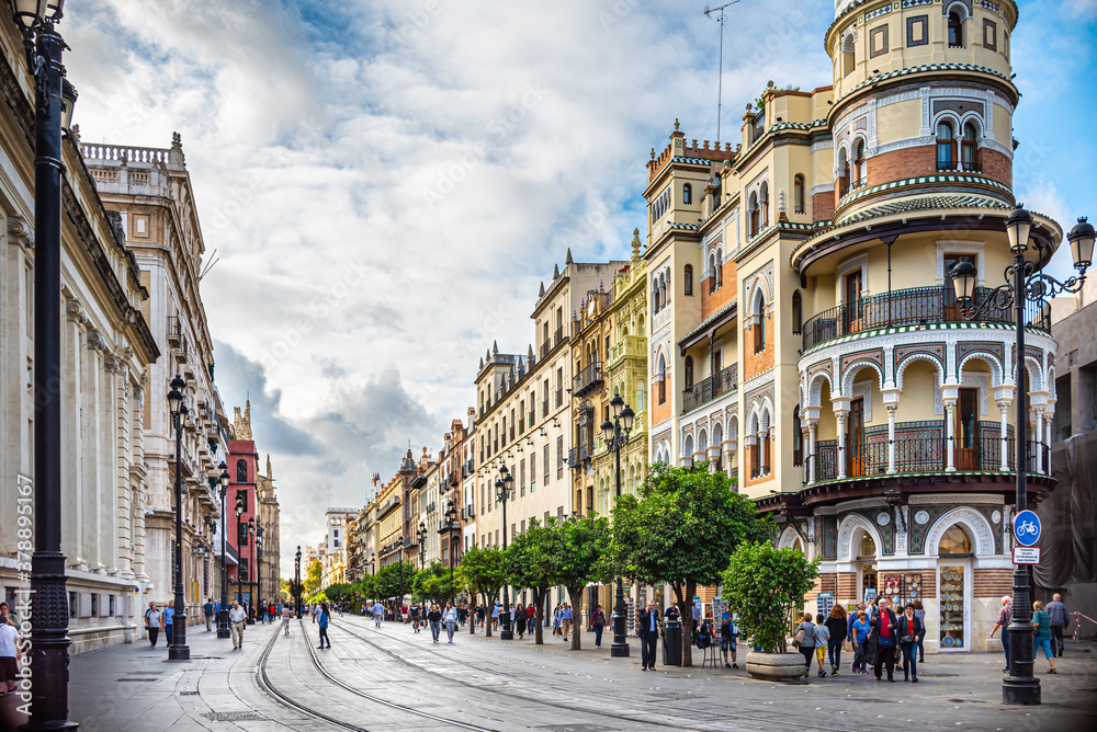 Naklejka premium Seville, Spain. October 14th, 2019. View of the Av. De la Constitución. On the right the building called La Adriatica. On the left the side facade of the Banco de Espana and the General Archive.