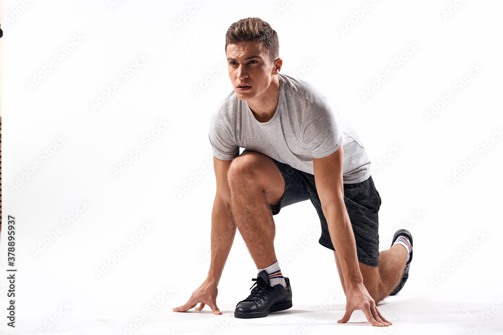 Athletic man on a light background in full growth and jogging charging shorts sneakers t-shirt Athletic man on a light background in full growth and jogging charging shorts sneakers t-shirt