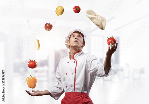 Young male chef juggles with food ingredients