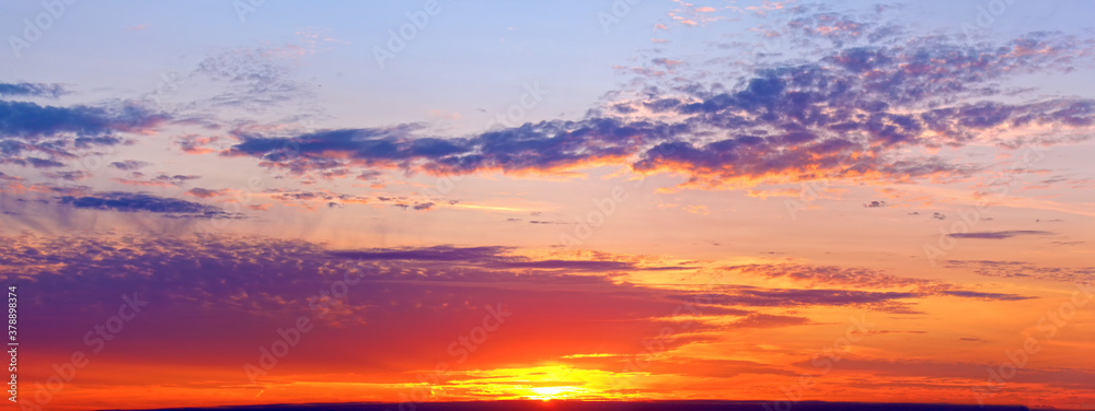 colorful sunset sky landscape background natural color of evening cloudscape ultra wide panorama with setting sun and clouds. Autumn colors of sky. Golden hour. Panoramic wallpaper