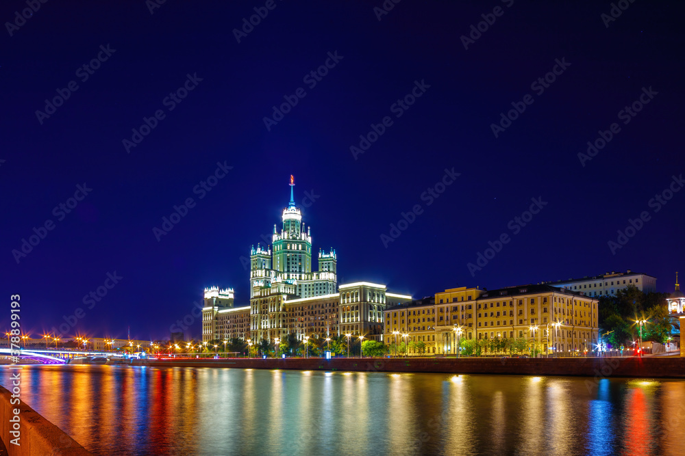 Stalin Skyscraper on Kotelnicheskaya Embankment of the Moscow River. Night shot of Moscow river reflection.