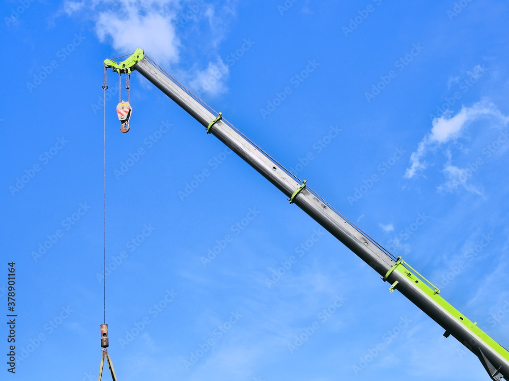 Obraz premium Isolated section of a heavy duty crane equipment lifting a container.