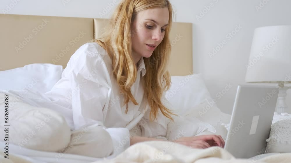 blonde woman working at laptop in the bedroom white style blonde woman working at laptop in the bedroom white style