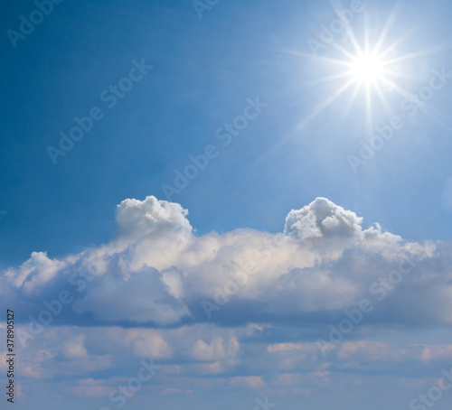 sparkle sun over a dense cumulus clouds  blue sky natural background