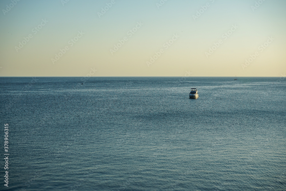 beautiful white motor yacht in the black sea in the evening at sunset off the coast of Anapa