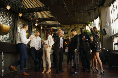 corporate businesspeople having fun and talking together in party