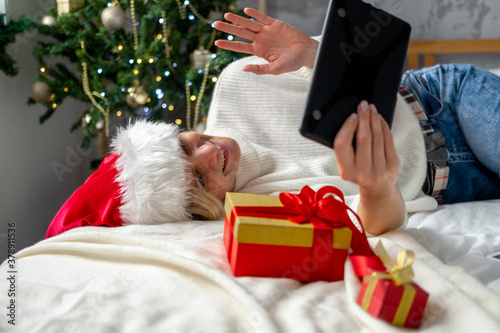 Christmas online congratulations. Smiling woman using mobile tablet for video call friends and parents.
