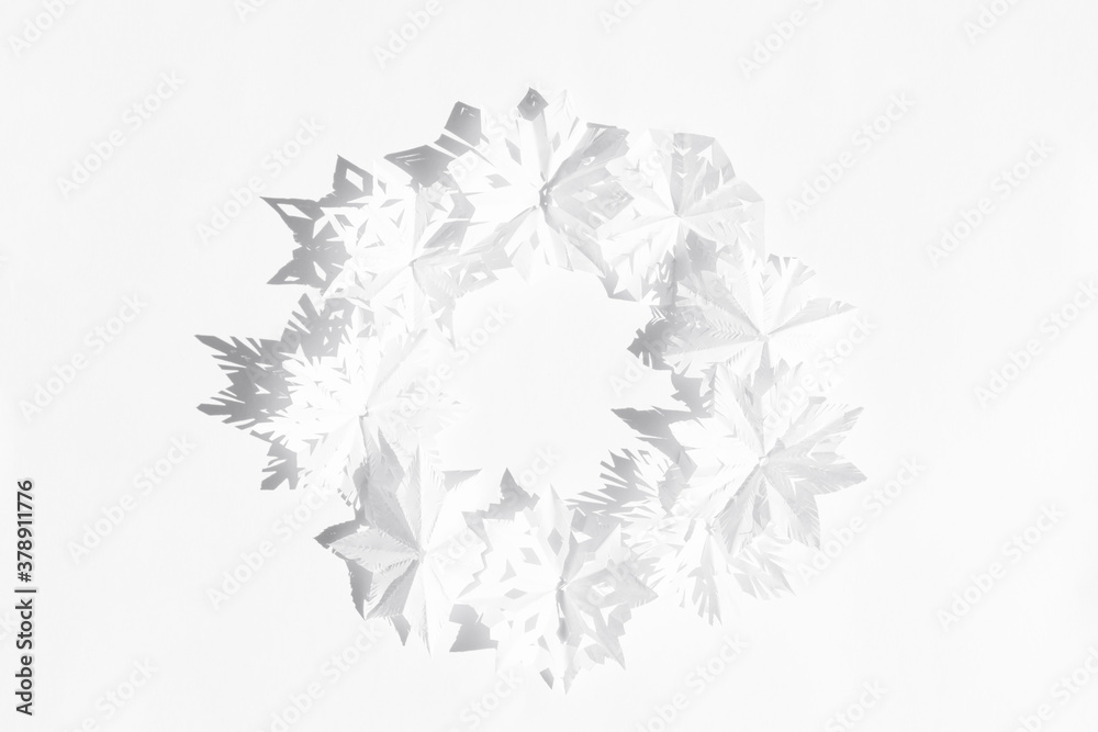 frame of paper cut snow flakes on a white background