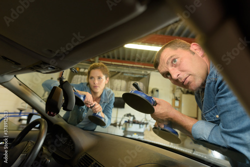 mechanic removing windshield using suction tool © auremar