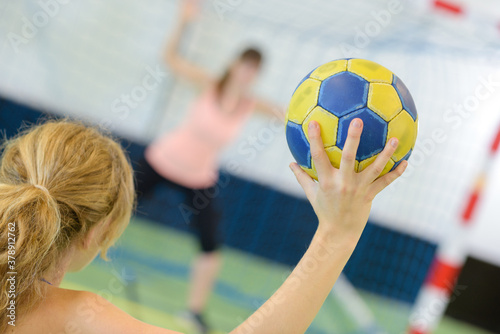 Fényképezés sportswoman holding a ball against handball field indoor
