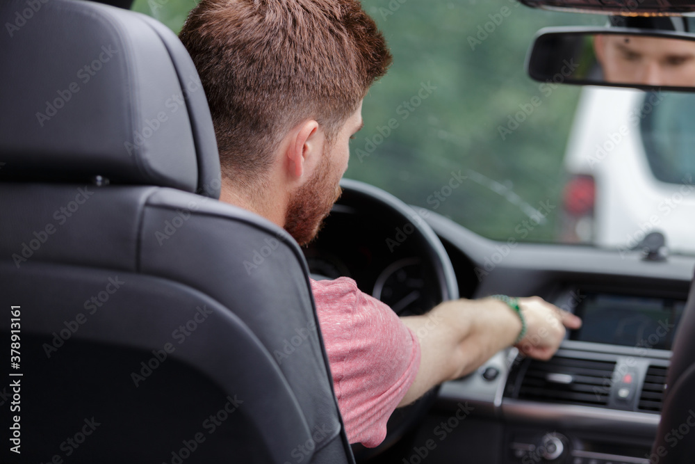 man touching dashboard while sitting in car man touching dashboard while sitting in car