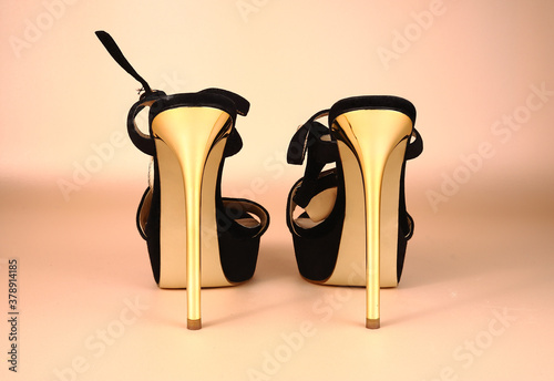 Quadro su tela Sandals with gold high heels on a pink background