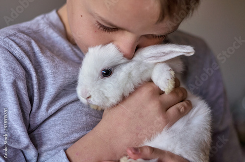 a boy with a white rabbit in his hands