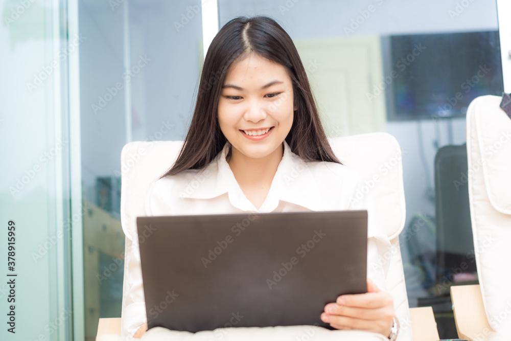 Business women sitting on sofa wooden chair use laptop computer in modern room Business women sitting on sofa wooden chair use laptop computer in modern room