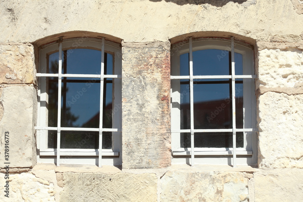 Obraz premium Altes Fenster mit Fenstergitter an einer hellen Hauswand, Deutschland, Europa