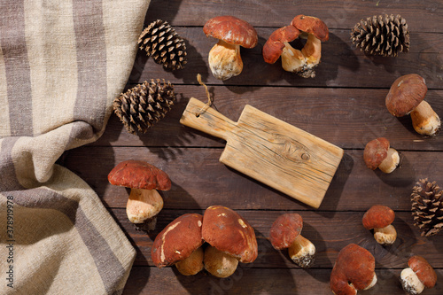 Harvest concept. Wild porcini mushrooms in a handmade wicker basket on a wooden background top view. Flat lay.