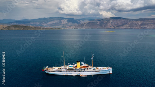 Aerial drone photo of classic wooden yacht anchored in Mediterranean bay with deep blue sea