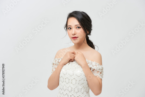 Elegant bride in a white dress on white background
