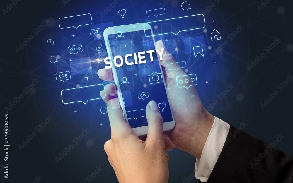Female hand typing on smartphone with SOCIETY inscription, social media concept Female hand typing on smartphone with SOCIETY inscription, social media concept