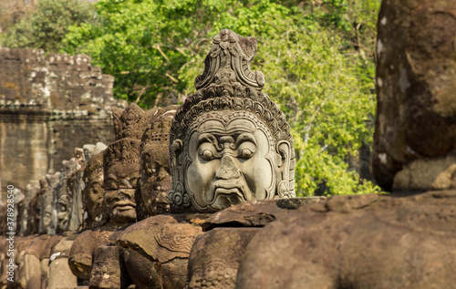 Ancient gatekeeper stone statue in front of the ruins of angkor wat